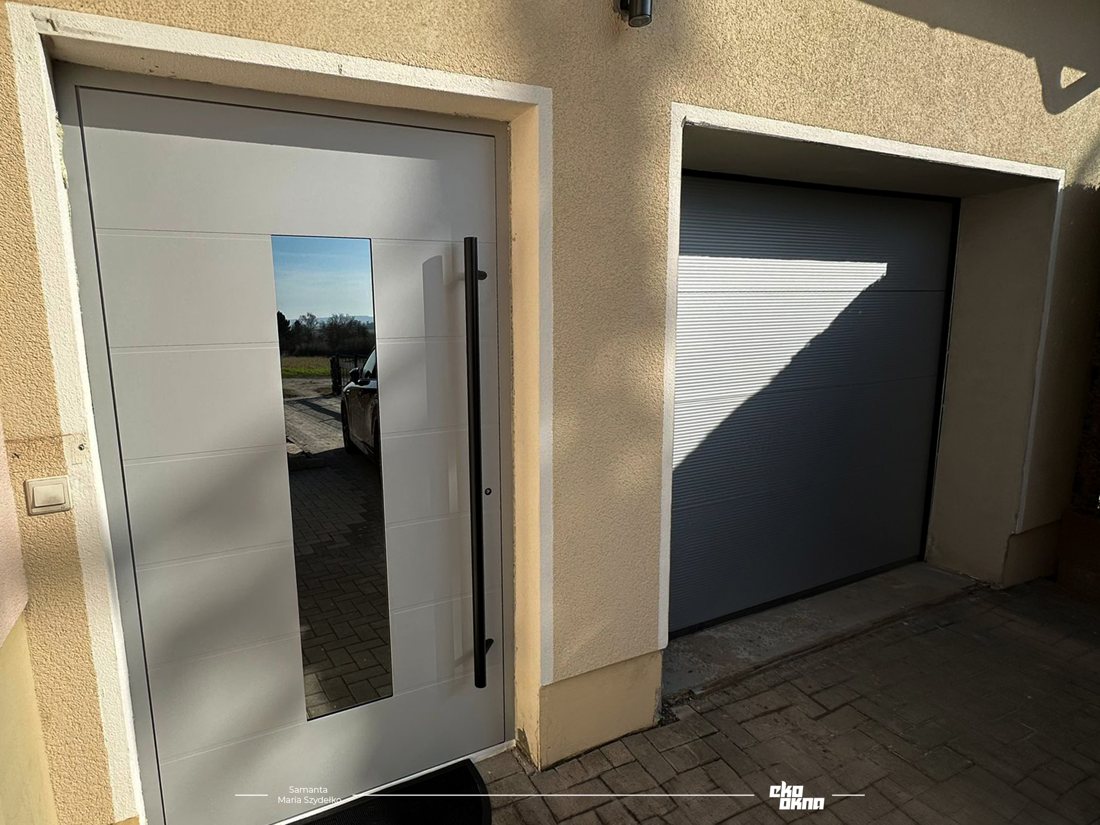 Aluminium-Haustür mit Glasstreifen, daneben Garagentor